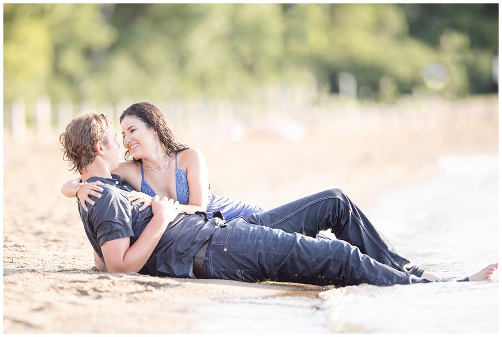 Couple laying on the shore of Wall Lake, South Dakota during sunset