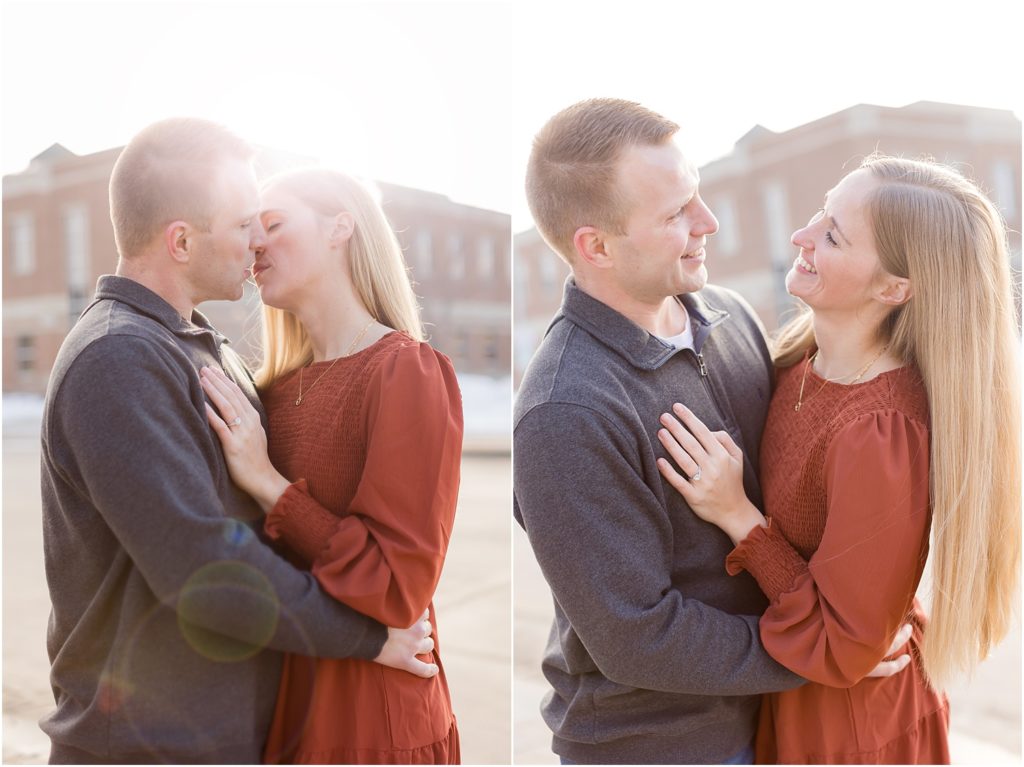 Engaged couple walking Downtown Sioux Falls during winter smiling