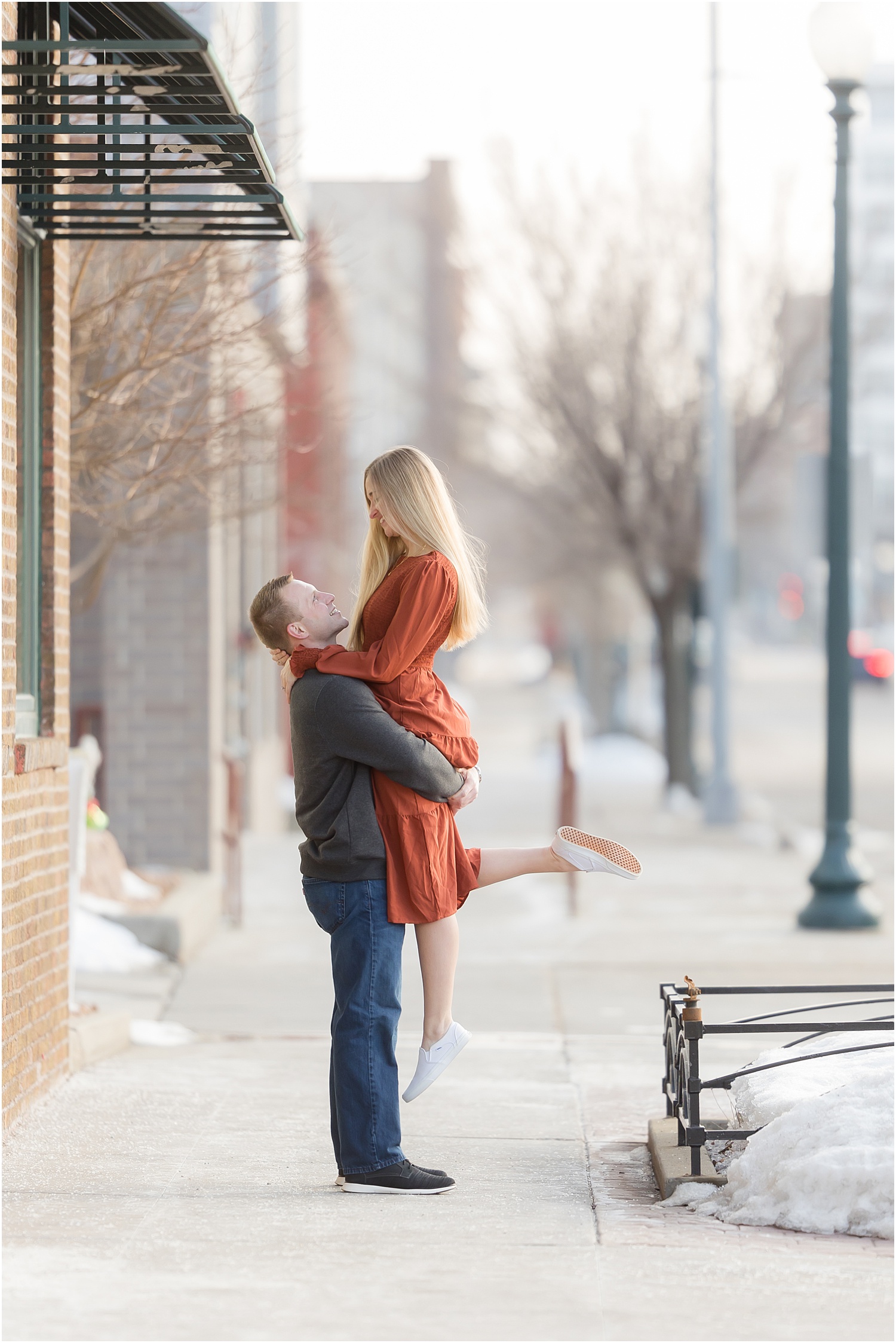 Engaged couple walking Downtown Sioux Falls during winter