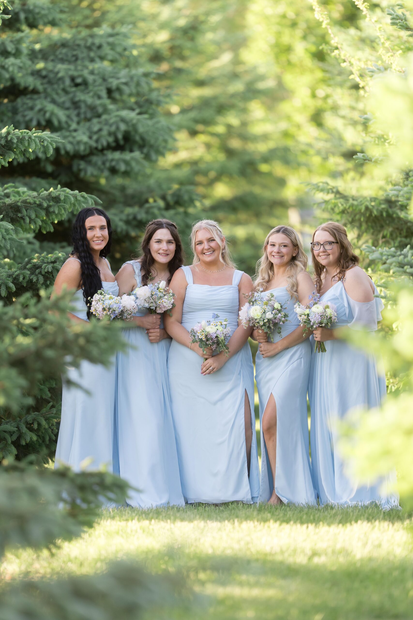 Bridesmaids-wearing-mismatched-dresses-in-soft-pastel-tones,-smiling-together-at-a-wedding-in-SiouxFalls-SouthDakota