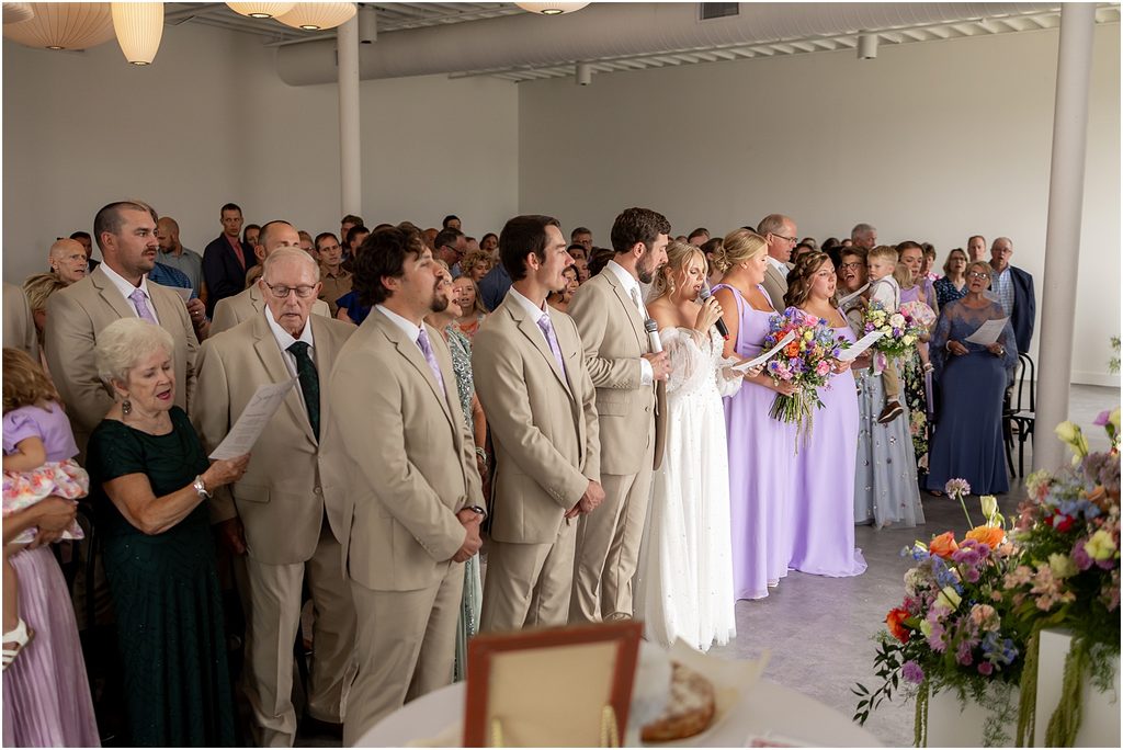 Bride and groom singing with their guests during their Wedding ceremony at Monick Yards wedding venue. Sioux Falls, SD