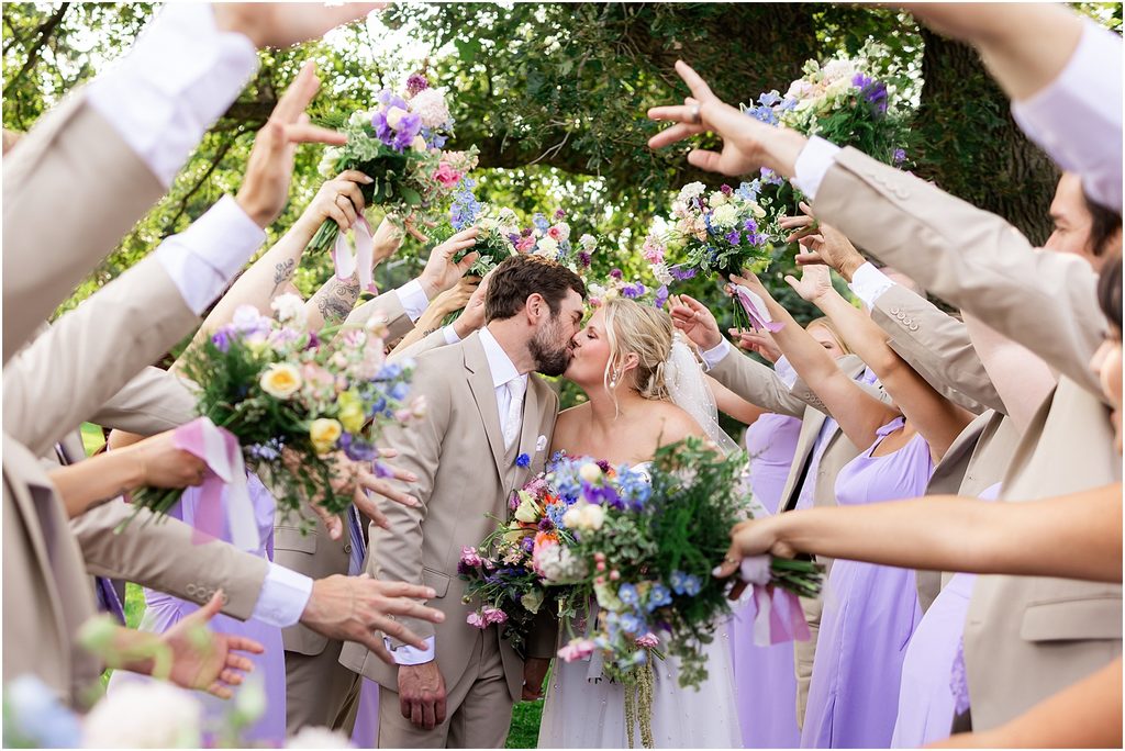 Bridal party celebrating with bride and groom at Sioux Falls, South Dakota. Champagne and purple colors and captured by luxury wedding photographer Patty Solis Photography.